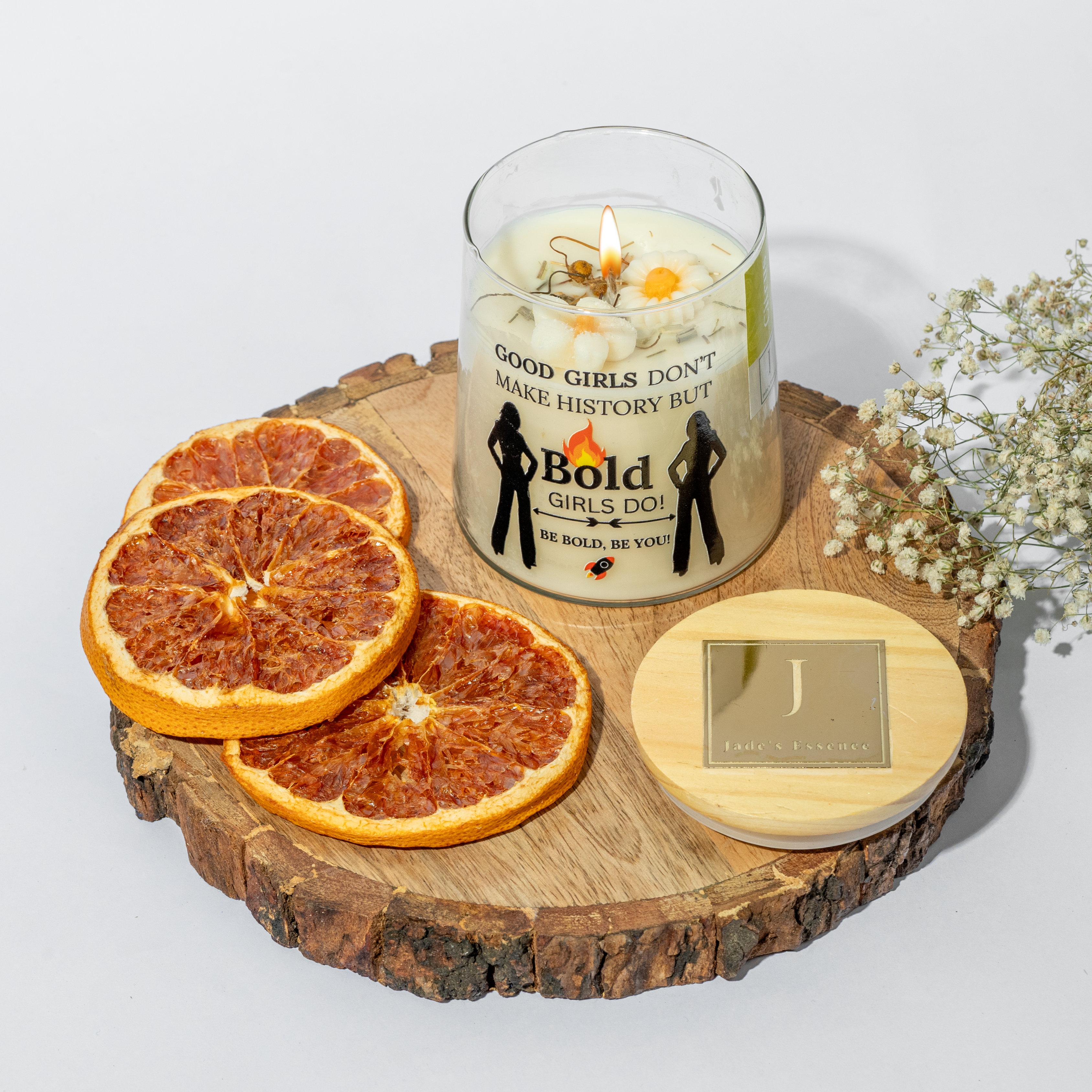 eco friendly Candle with motivational message on a wooden board with dried oranges and flowers