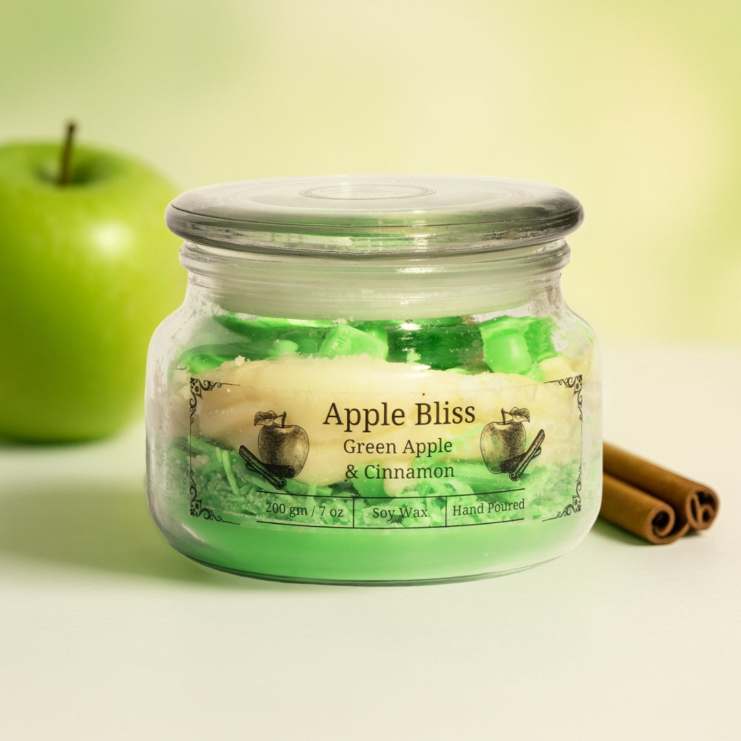 Jar of 'Apple Bliss' eco friendly candle with a green apple and cinnamon sticks on a light background