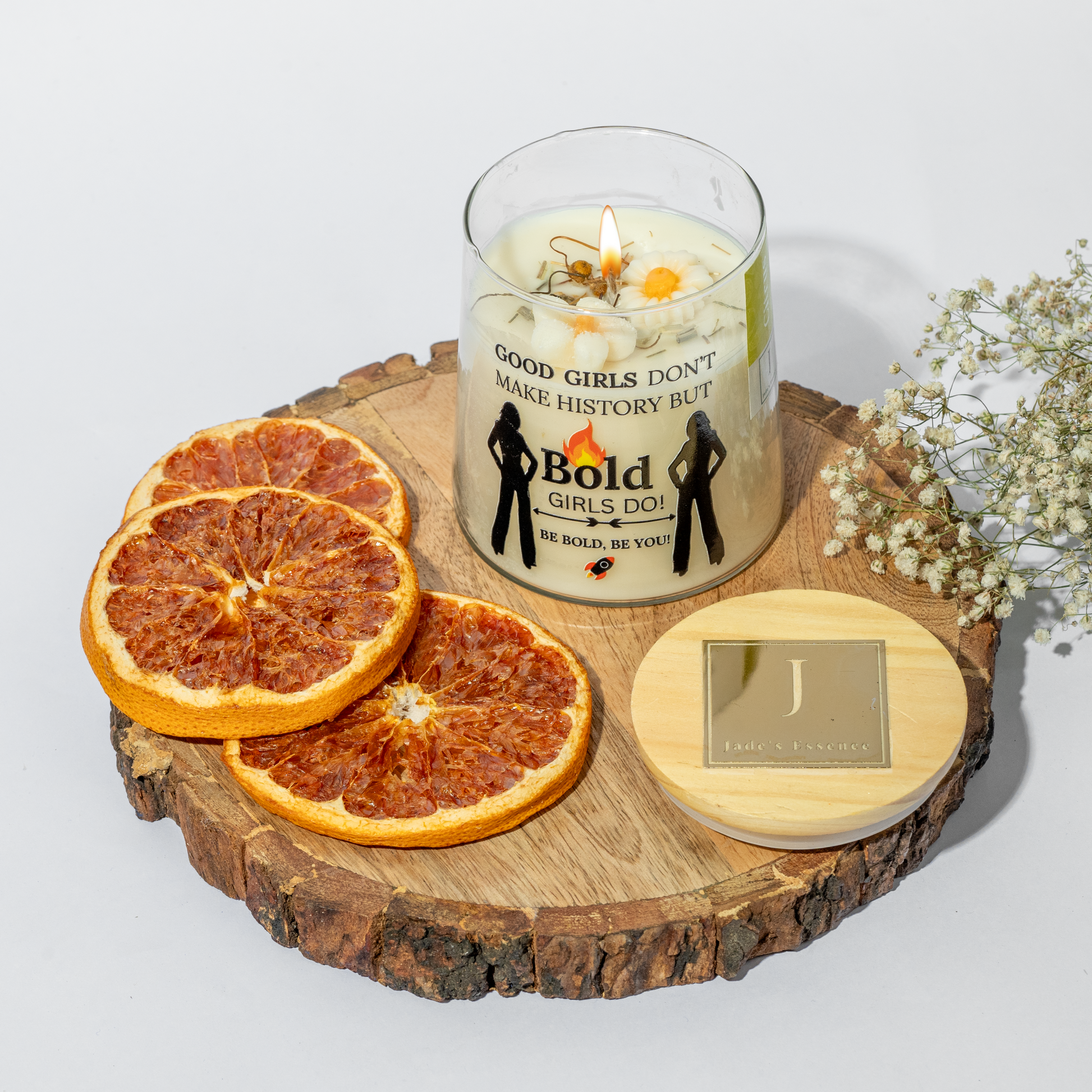eco friendly Candle with motivational message on a wooden board with dried oranges and flowers