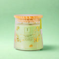 eco friendly candle with decorative label on a light green background