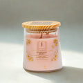 eco friendly candle in a glass jar with a wooden lid on a light background