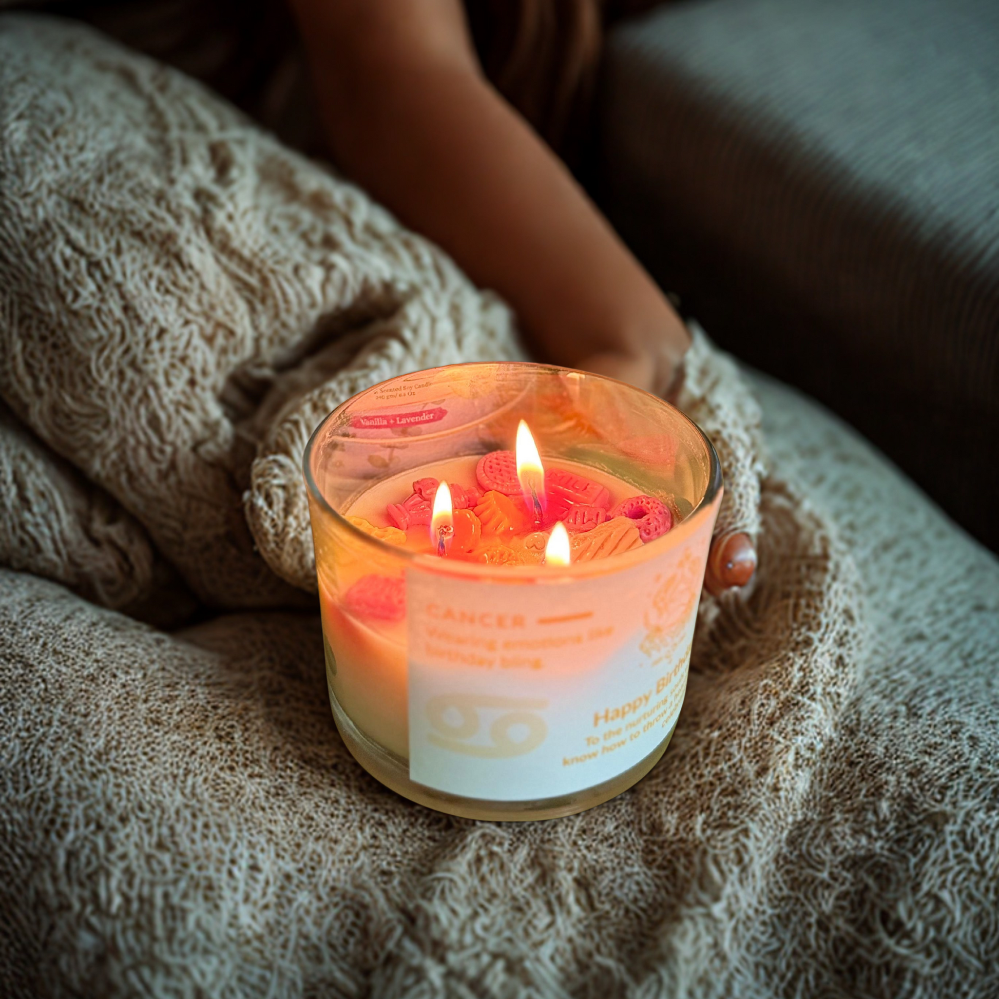 ecofriendly Candle with a label held by a person wrapped in a blanket
Eco friendly candle 
Zodiac candle