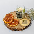 eco friendly Candle with motivational message on a wooden coaster with dried oranges and flowers