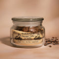 Glass jar eco friendly candle labeled 'Scotch Glow' with coffee beans on a beige background