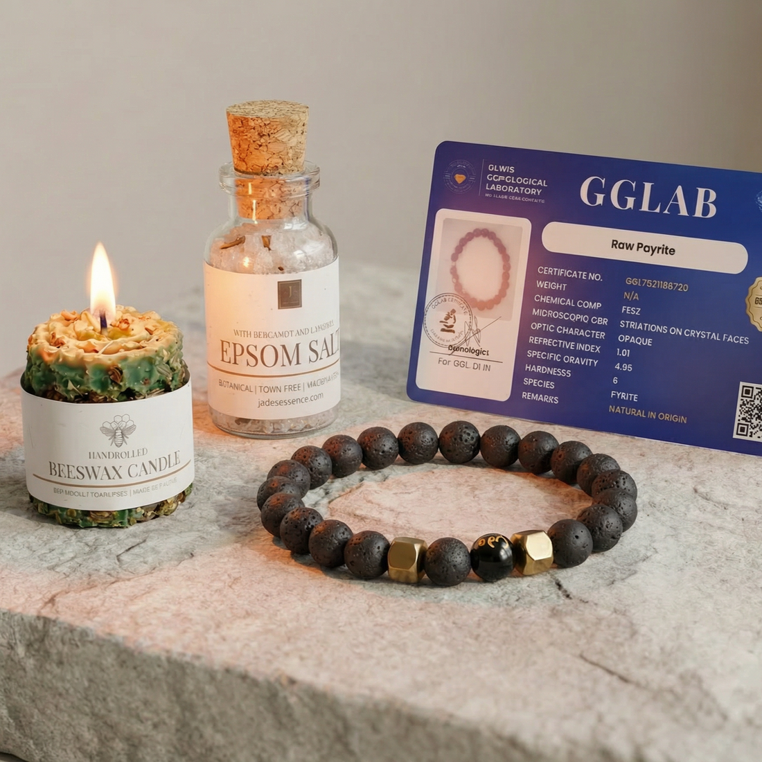 Beeswax candle, Epsom salt bottle, and bracelet on a stone surface with a GGLAB card in the background.