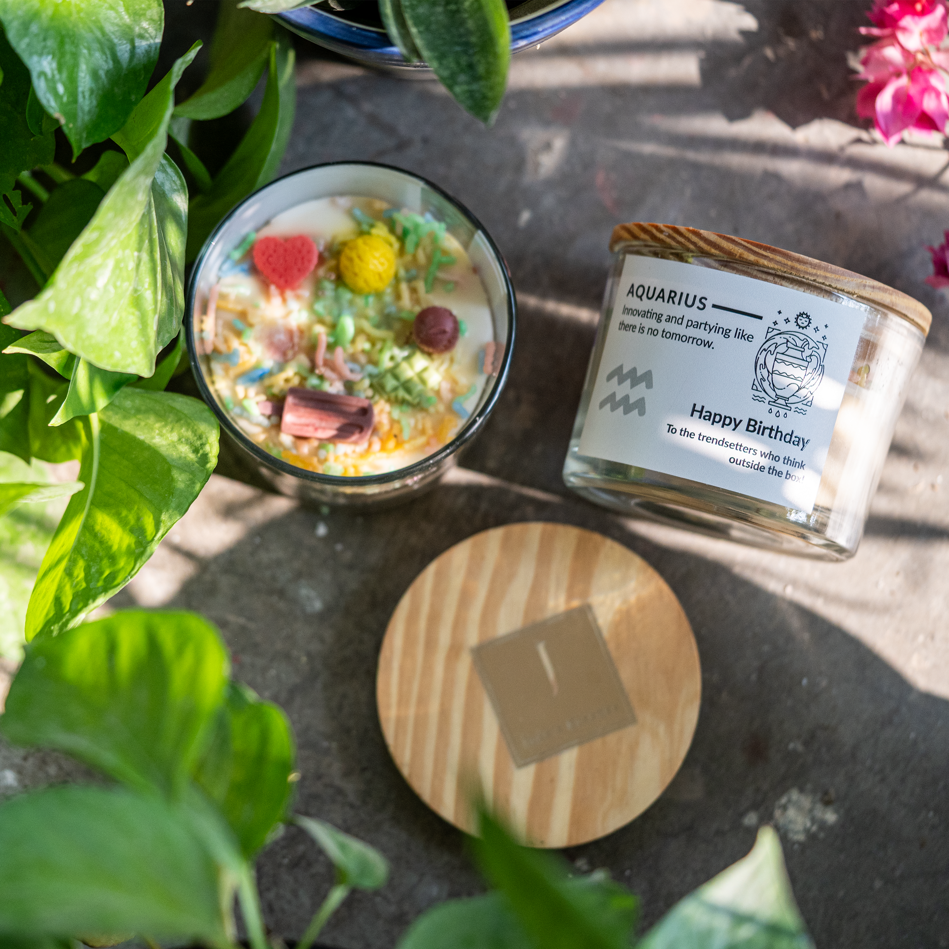 ecofriendly Candle with decorative elements and a label on a stone surface with plants around