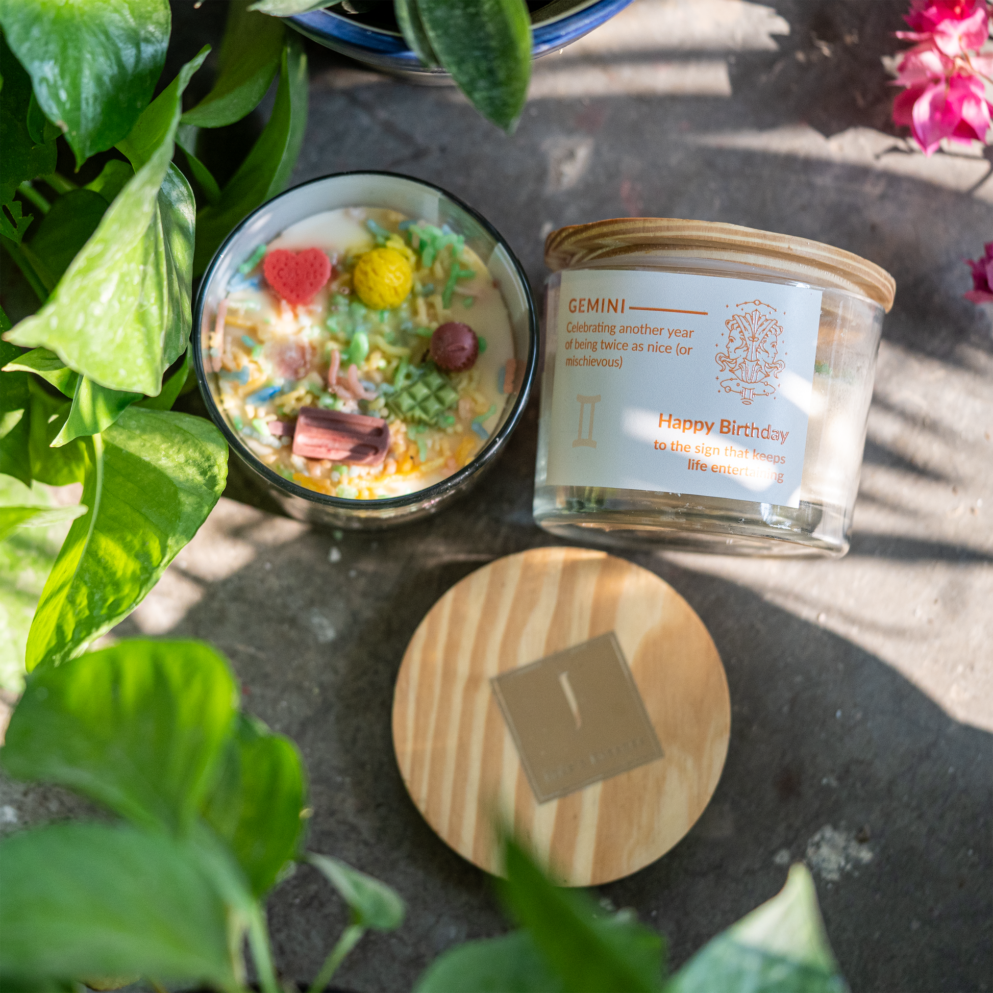 ecofriendly Candle with decorative elements and a labeled candle on a stone surface with plants around.