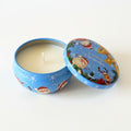 Christmas-themed candle in a tin with Santa Claus and reindeer design on a white background