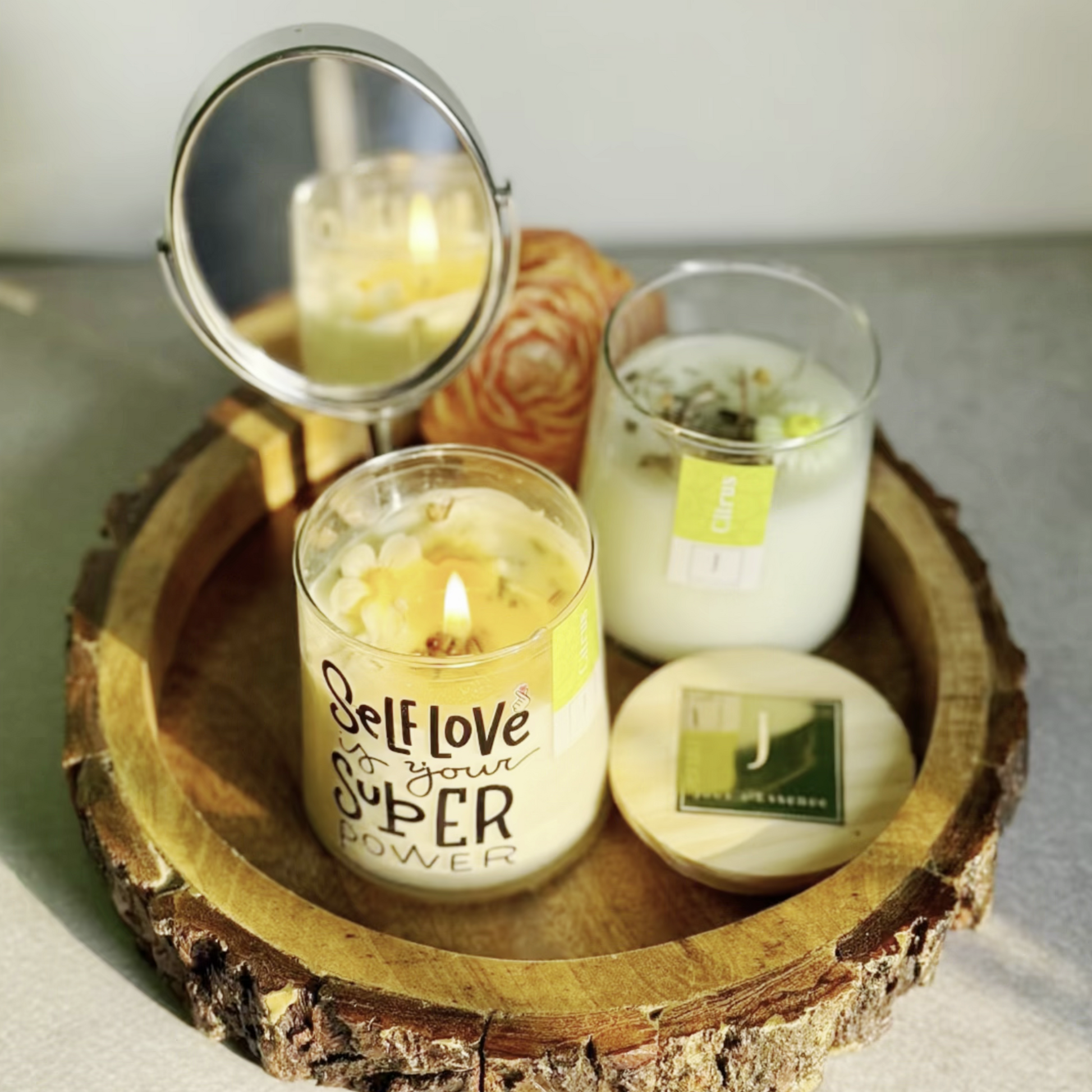 eco conscious ecofriendly Candles on a wooden tray with a mirror and small container
