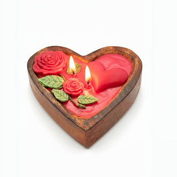 Heart-shaped wooden candle holder with red roses and a lit candle on a white background