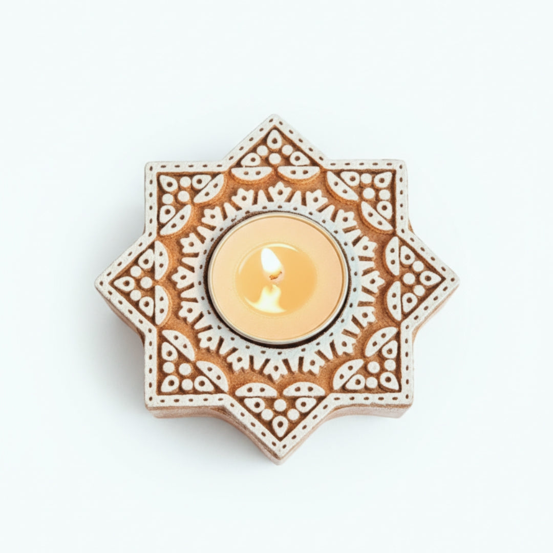 Decorative star-shaped candle holder with a lit candle on a white background