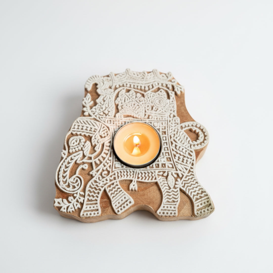 Decorative candle holder shaped like an elephant with intricate patterns on a light gray background