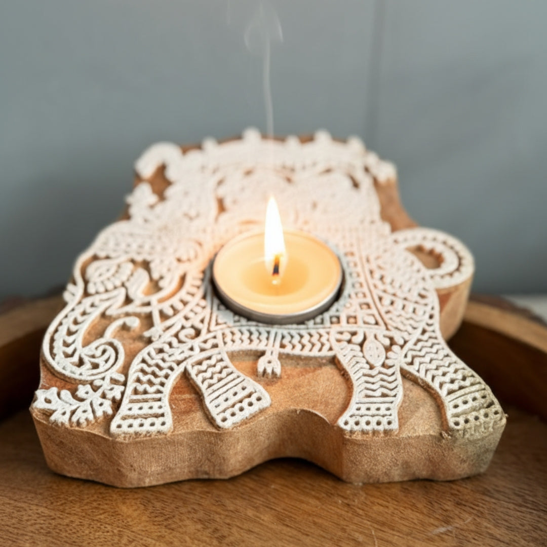 Decorative candle holder shaped like an elephant with intricate patterns on a light gray background