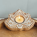 Wooden candle holder with intricate carvings on a wooden surface
