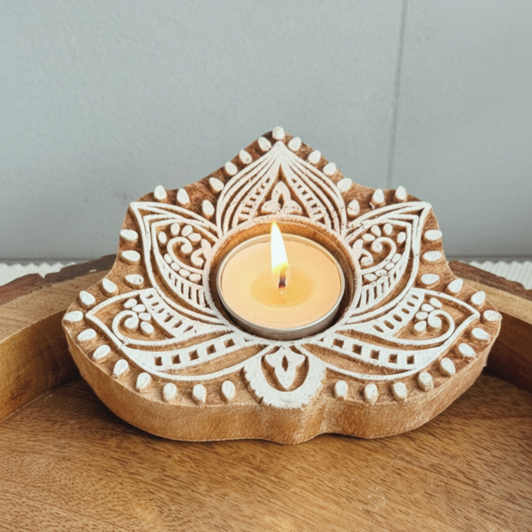 Wooden candle holder with intricate carvings on a wooden surface